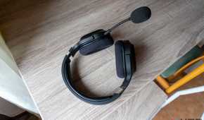 A Razer Barracuda X headset resting on a table with the detachable microphone plugged in