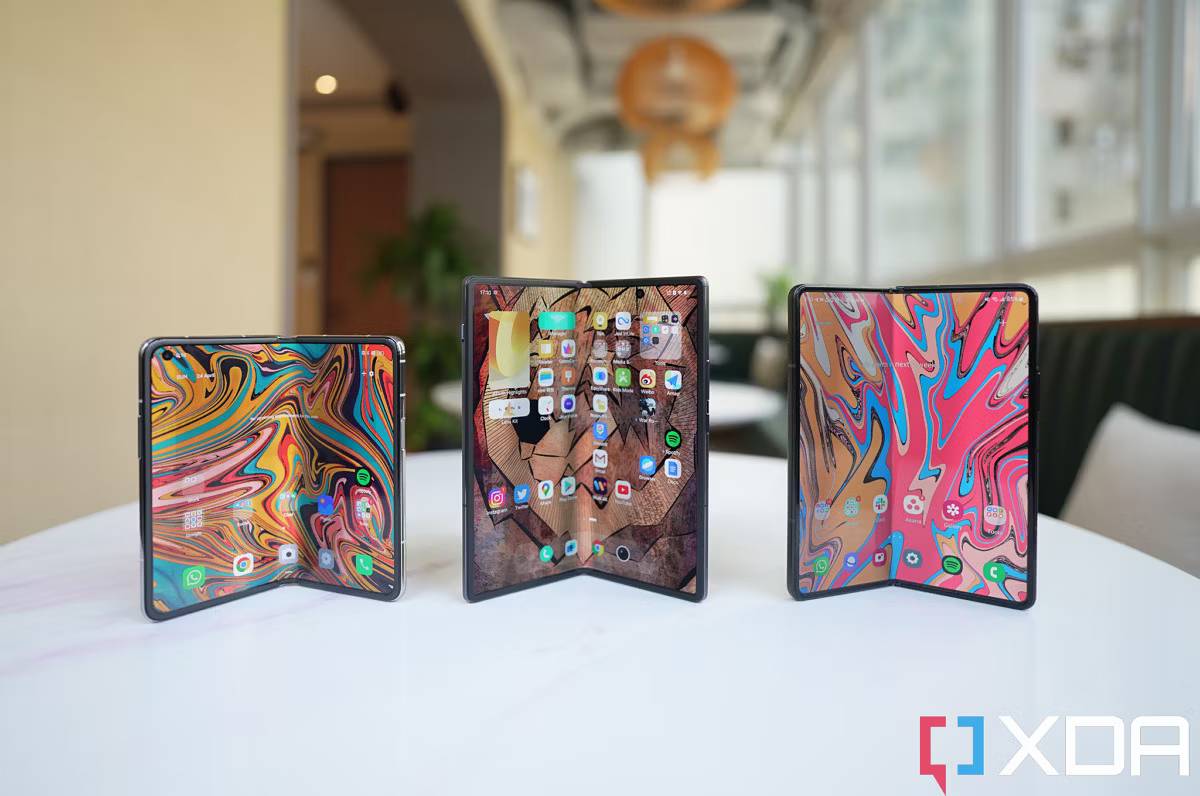 Three folding phones standing up with screens open