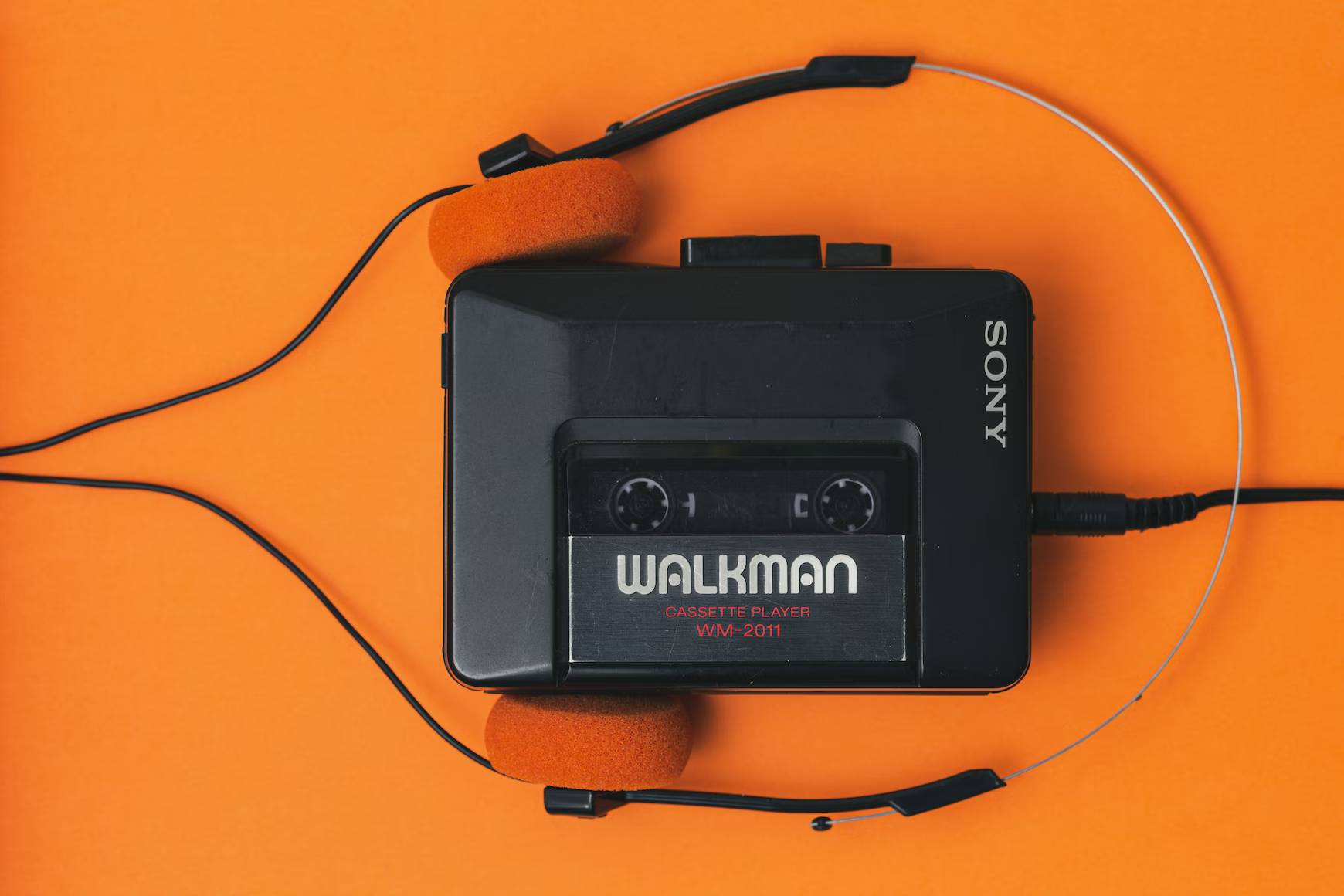 Sony Walkman with headphones on an orange table