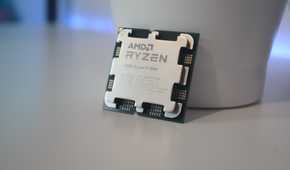 AMD Ryzen 9 7900 processor resting against a white container on a white desk