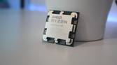AMD Ryzen 9 7900 processor resting against a white container on a white desk