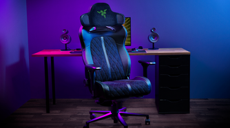 A gaming chair with a Razer-branded headrest mounted on it. The headrest has speakers on both sides.