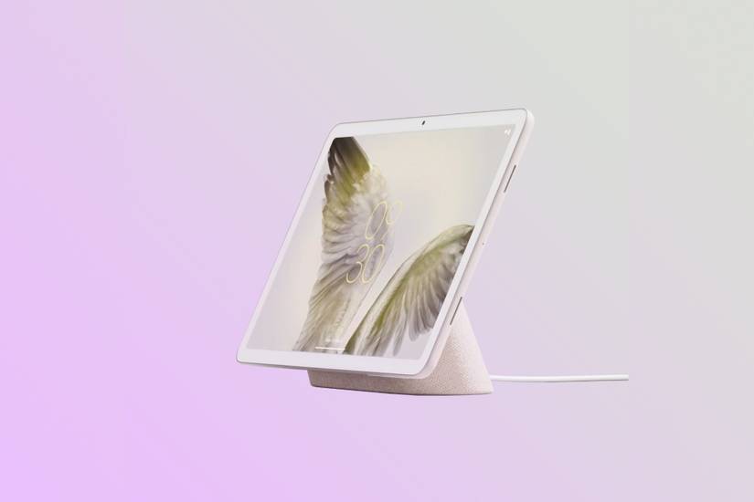 Google Pixel Tablet connected to dock on gradient background.