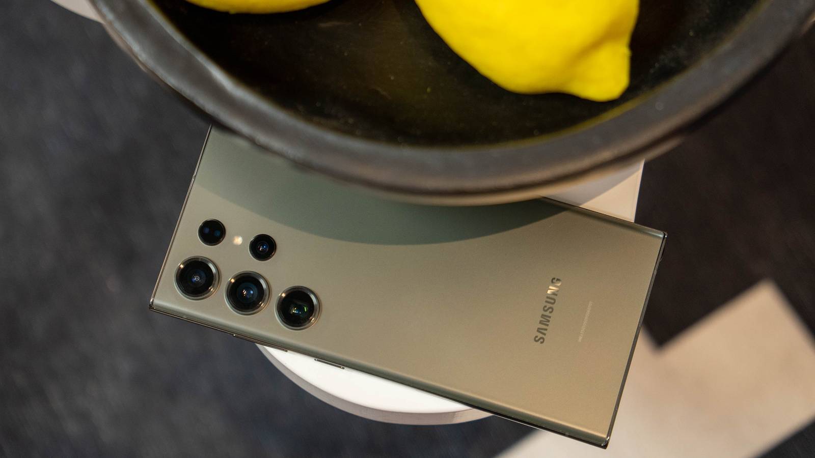 Green Samsung phone next t a bowl of lemons