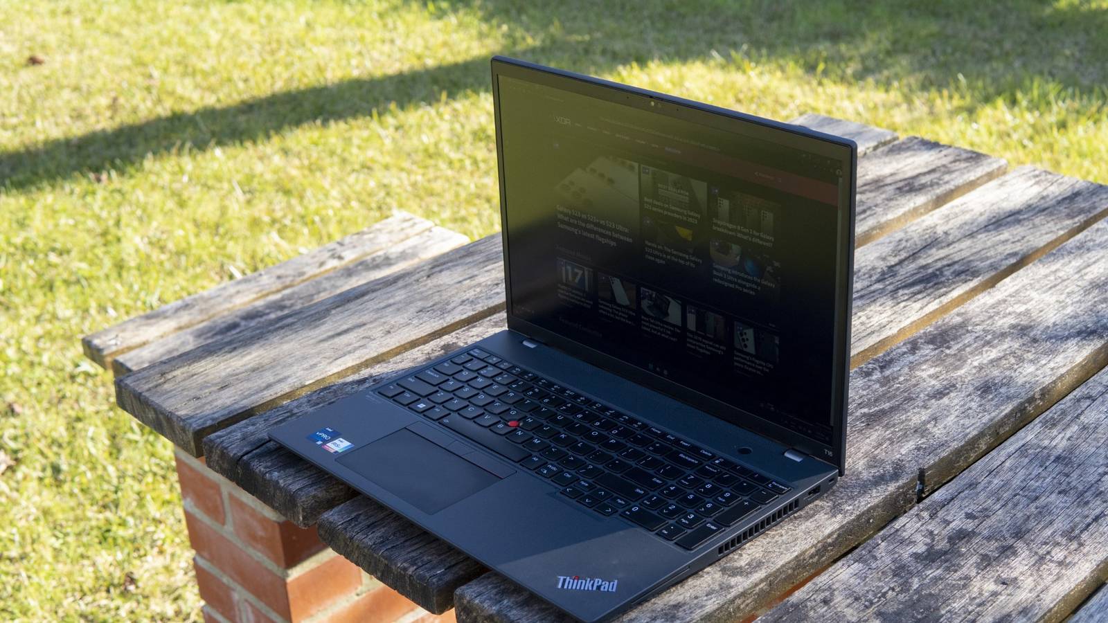 Angled front view of the Lenovo ThinkPad T16 on a wooden table facing left