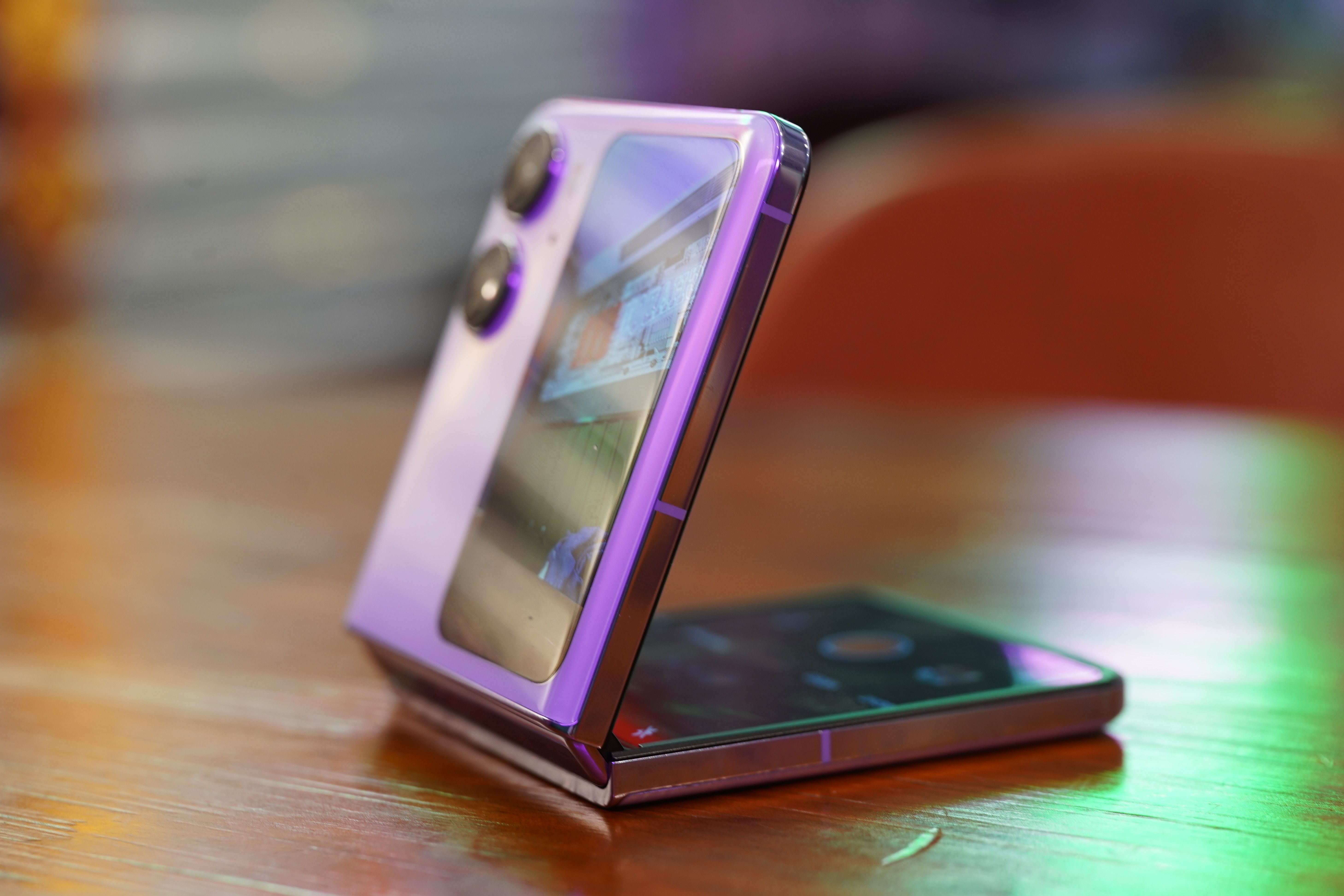 The Oppo Find N2 Flip in purple, on a table, half opened. 