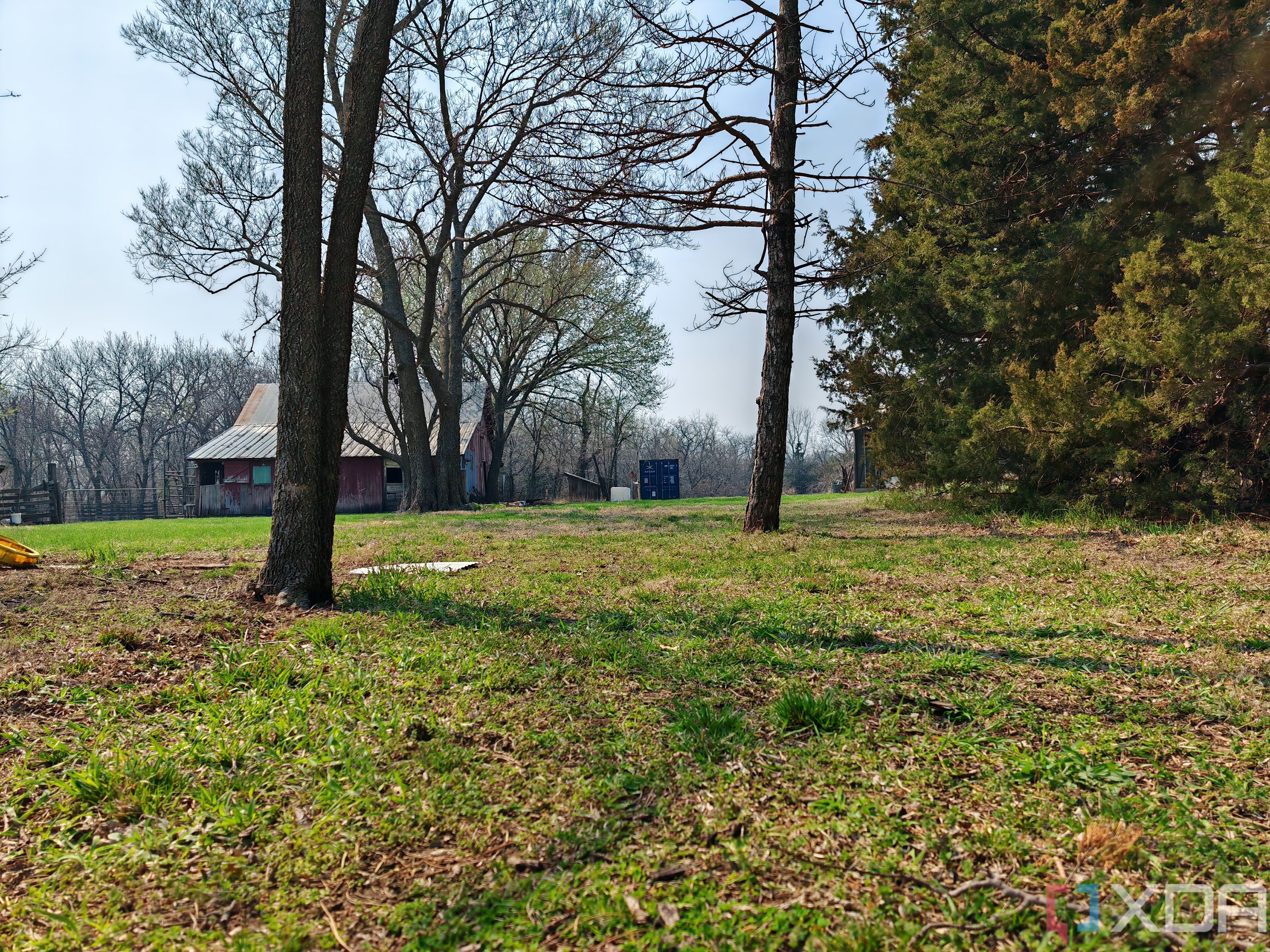 Outdoor photo of a barn and shipping container at 1x zoom
