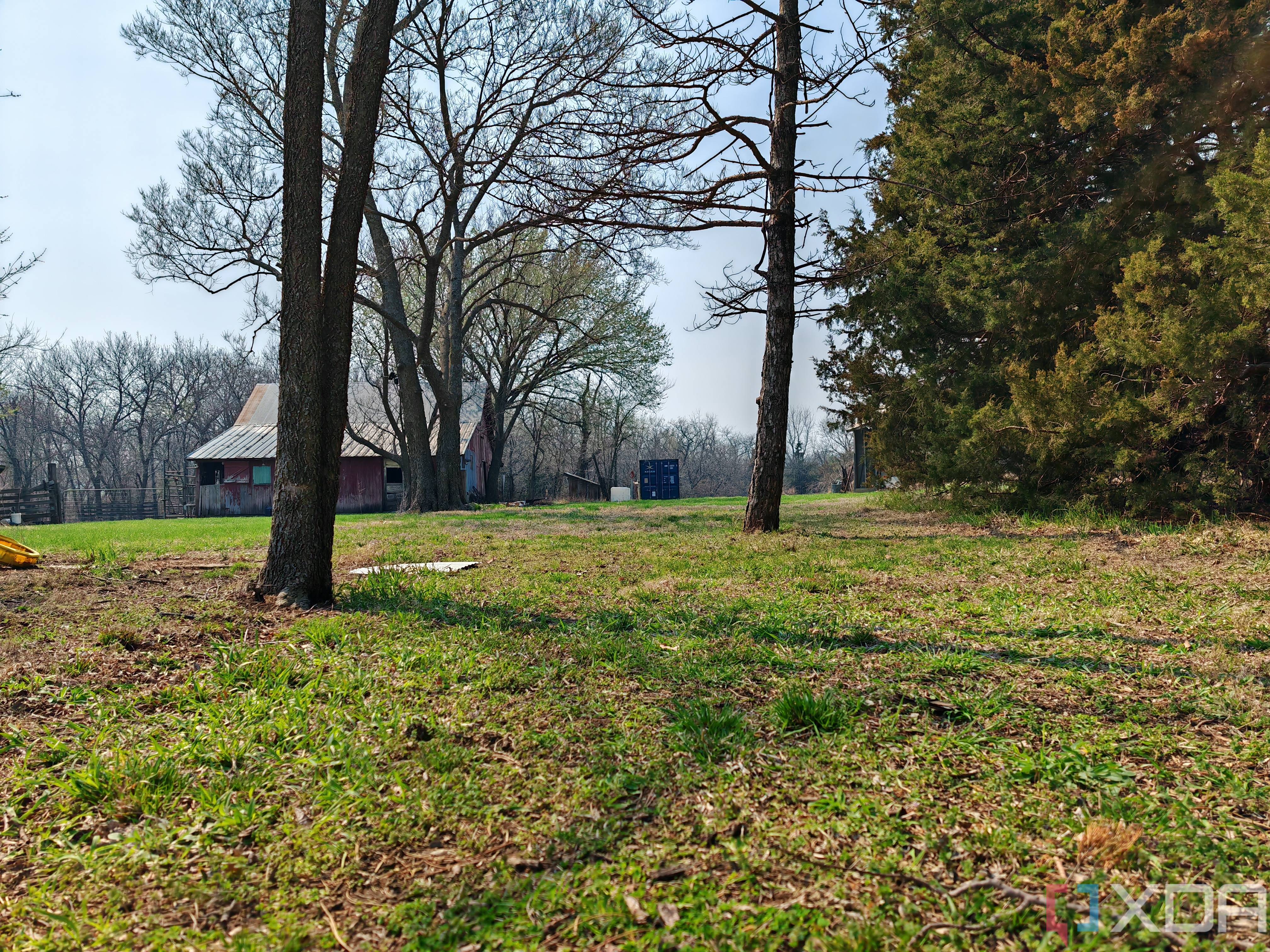 Outdoor photo of a barn and shipping container at 1x zoom