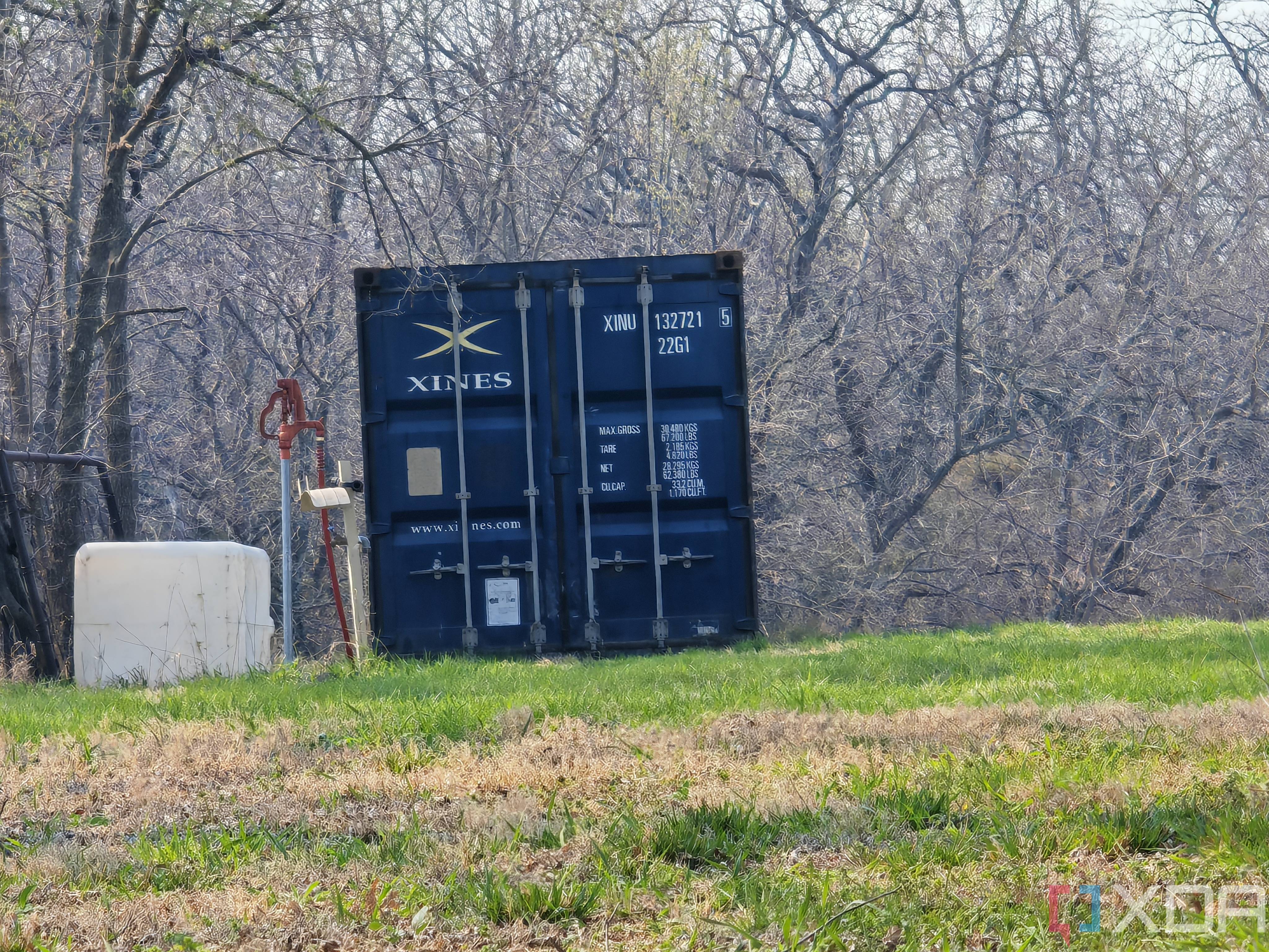 Outdoor photo of a barn and shipping container at 10x zoom