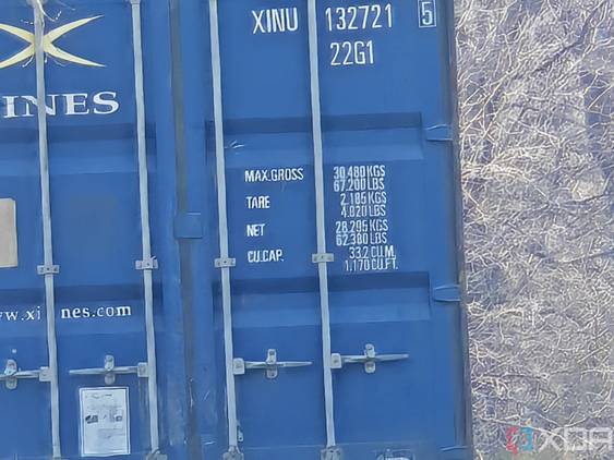 Outdoor photo of a barn and shipping container at 30x zoom