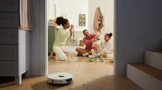 Roborock S7 Max Ultra cleaning up confetti with family in background.