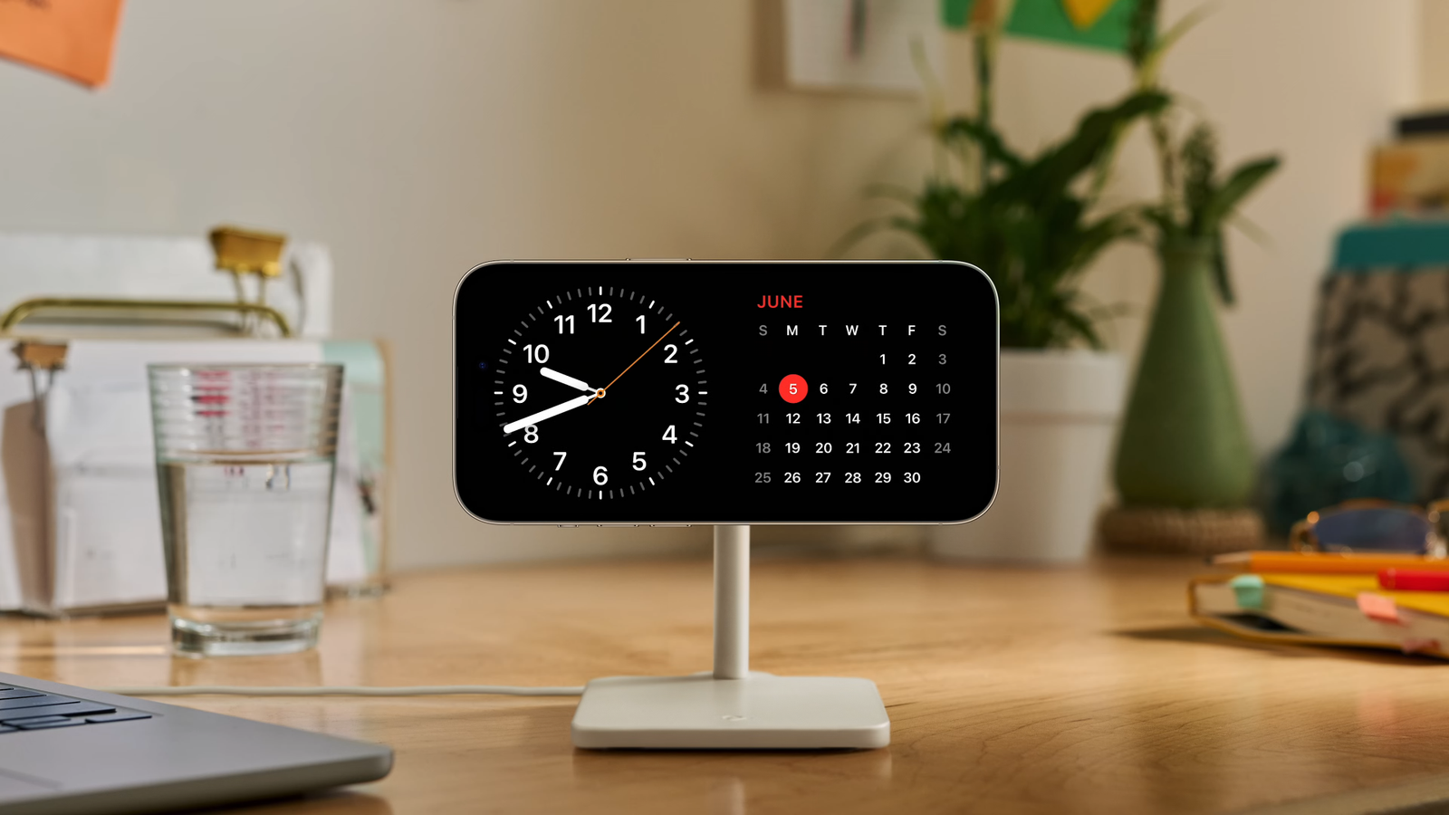 Standby in iOS 17 displaying the time and calendar on a wooden desk