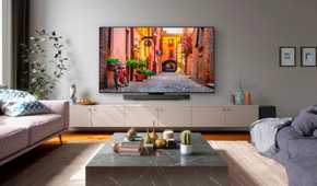 An image showing the LG C3 OLED TV mounted on a wall in a living room with couches and other furniture.