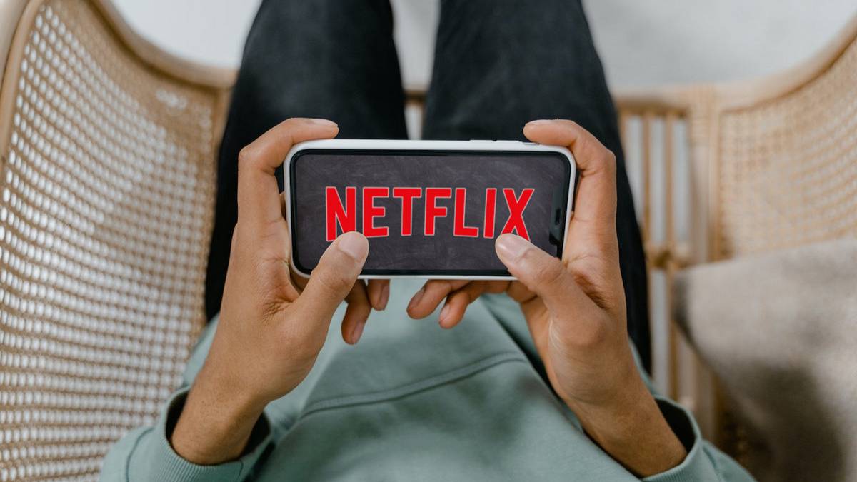 The Netflix logo displayed on a smartphone in a person's hand