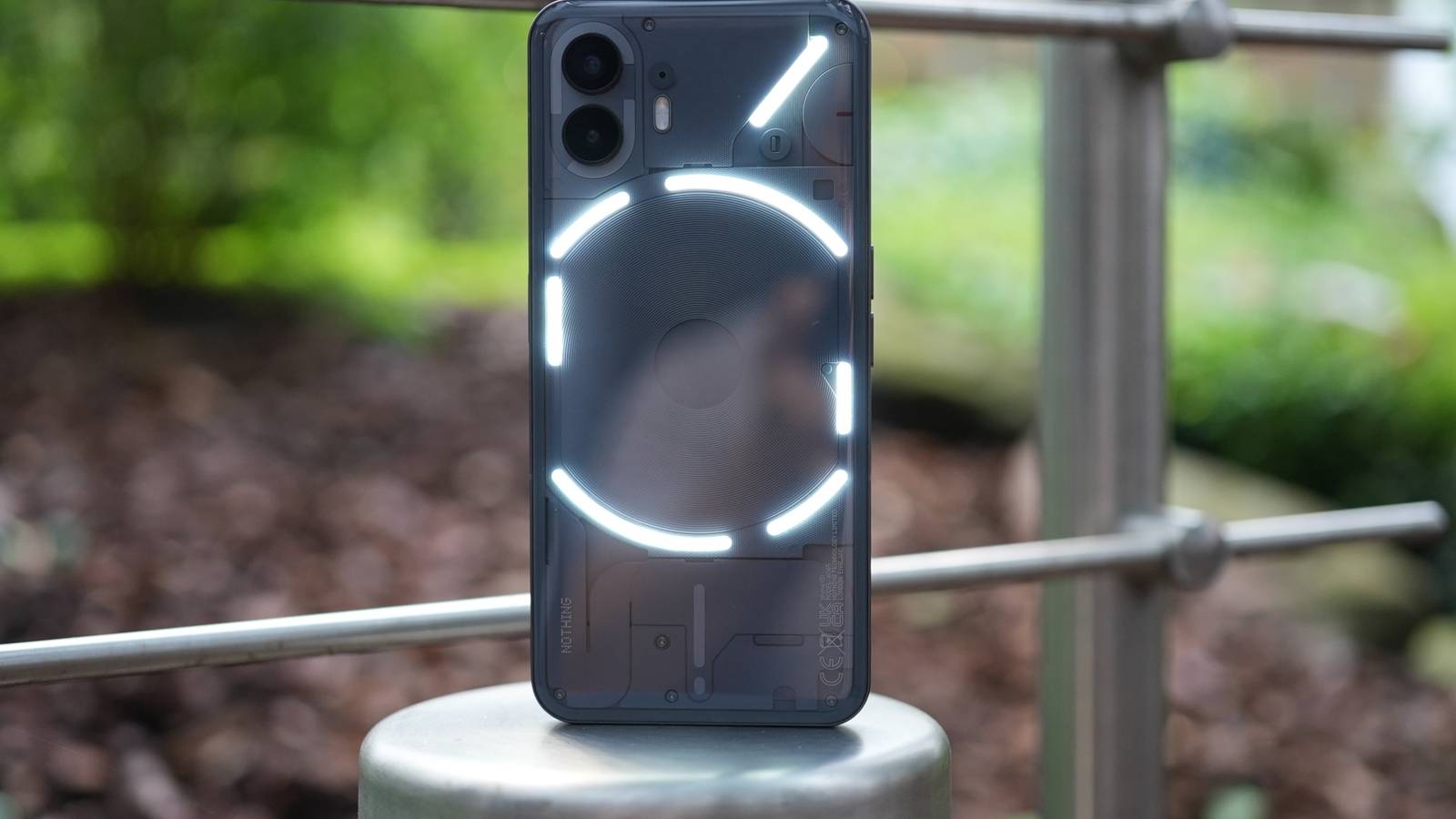 Nothing Phone 2 standing upright outside with glyph lighting interface on. 