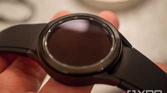 A Samsung Galaxy Watch 4 Classic held in someone's fingers