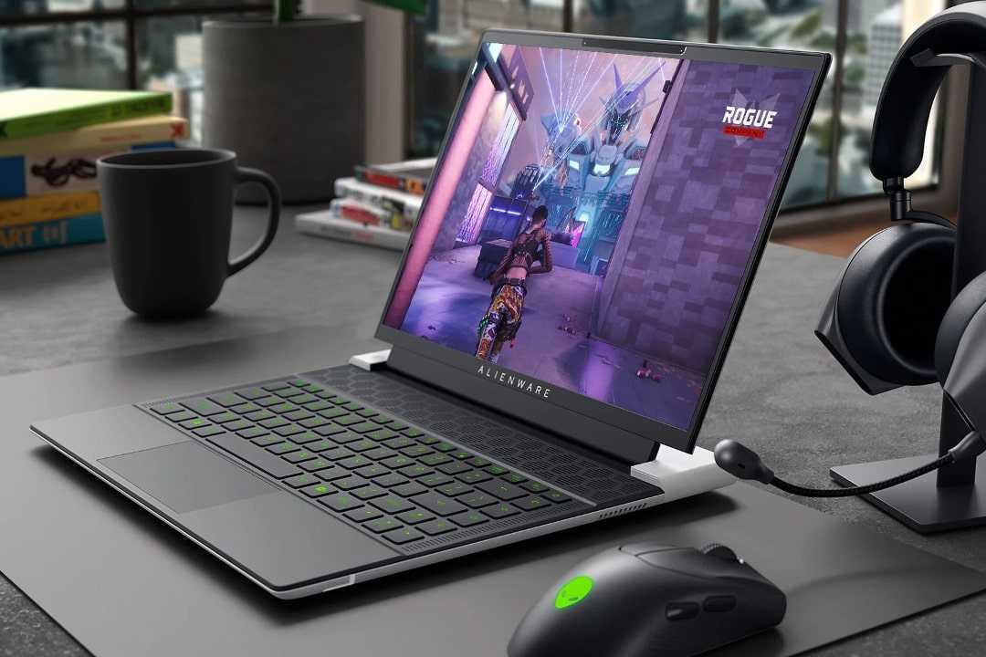 The Alienware x14 R2 on a desk next to an Alienware mouse and headphones.