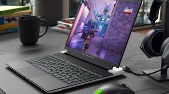 The Alienware x14 R2 on a desk next to an Alienware mouse and headphones.