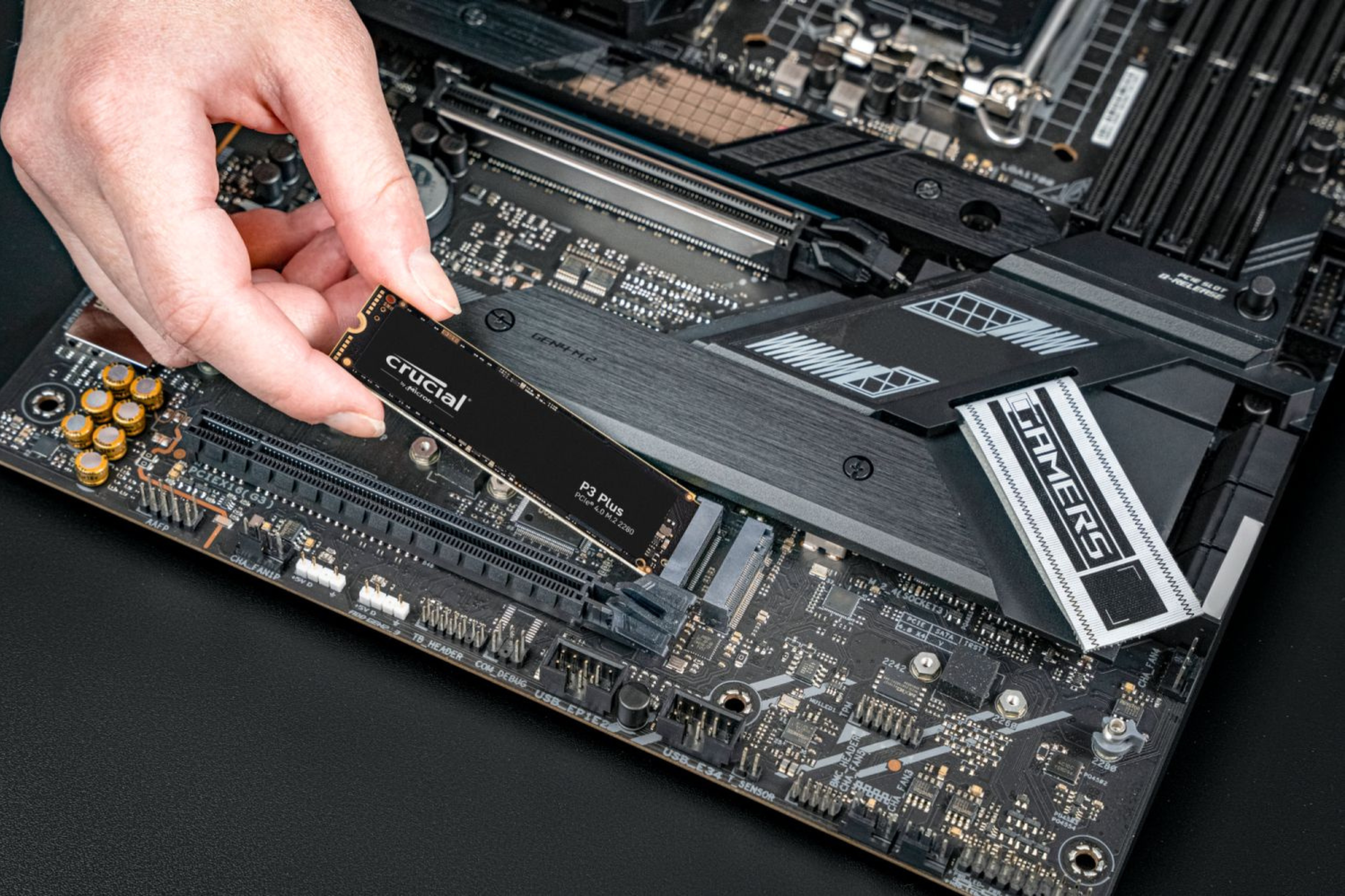 Crucial P3 Plus PCIe M.2 2280 SSD being installed into a motherboard.