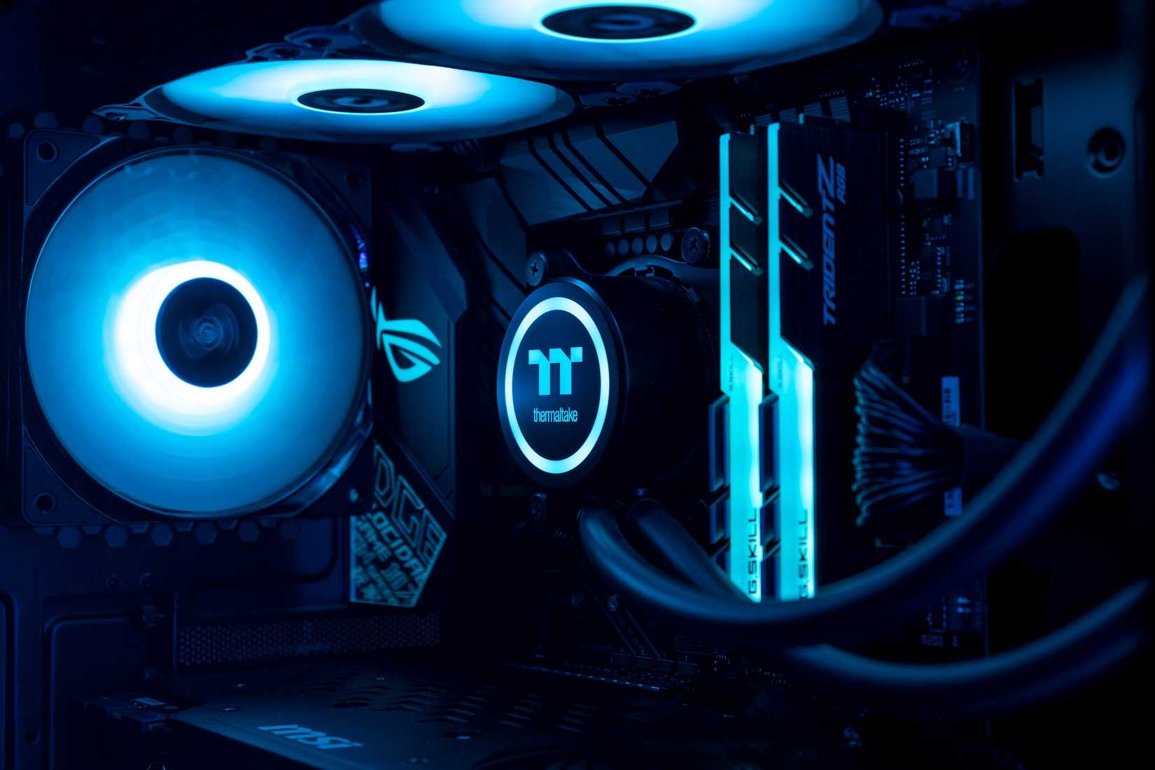 Close up of gaming PC showing fan, RAM, and CPU cooler in blue lighting