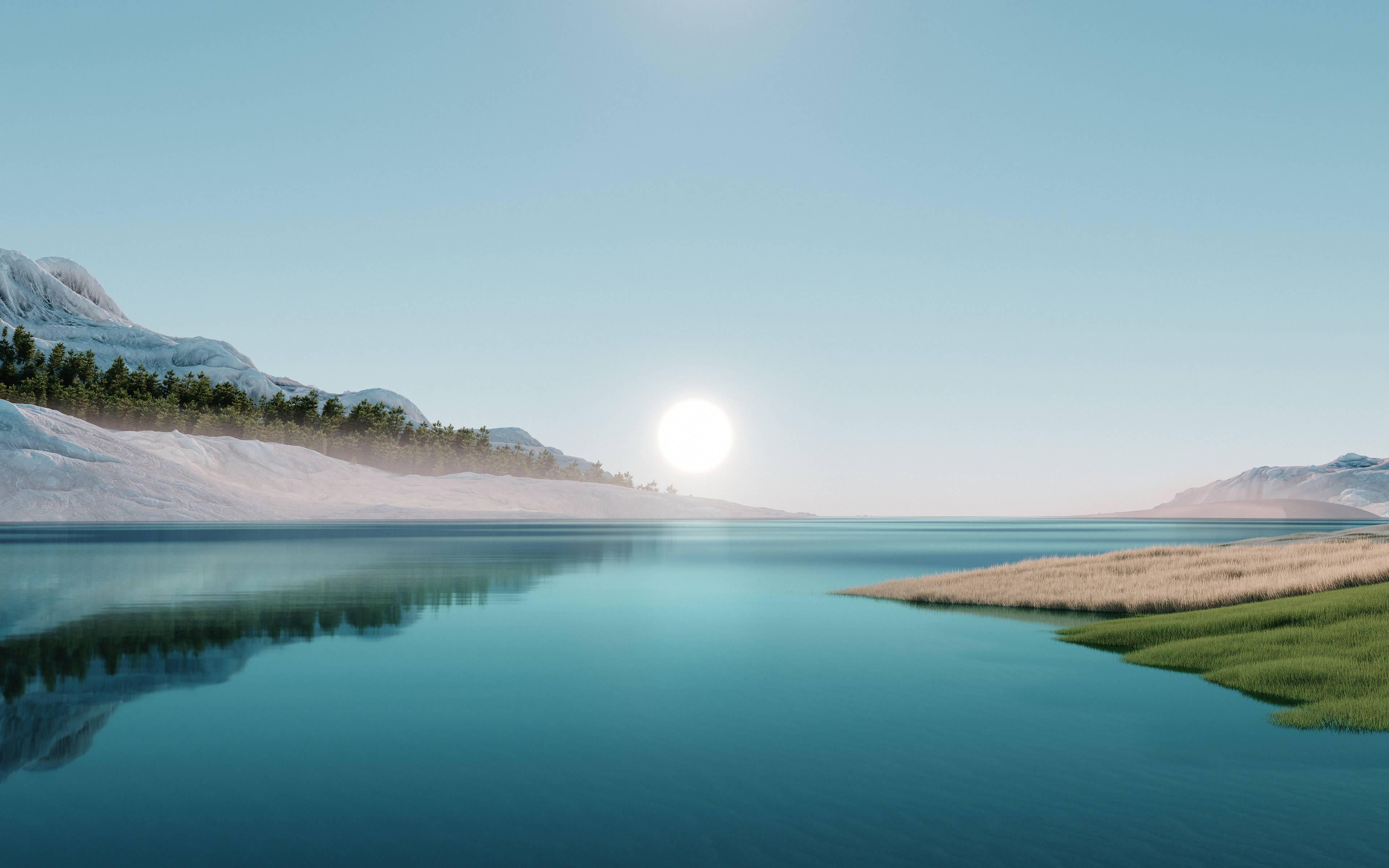 A clear lake surrounded by grassy landscapes and snow-covered mountains