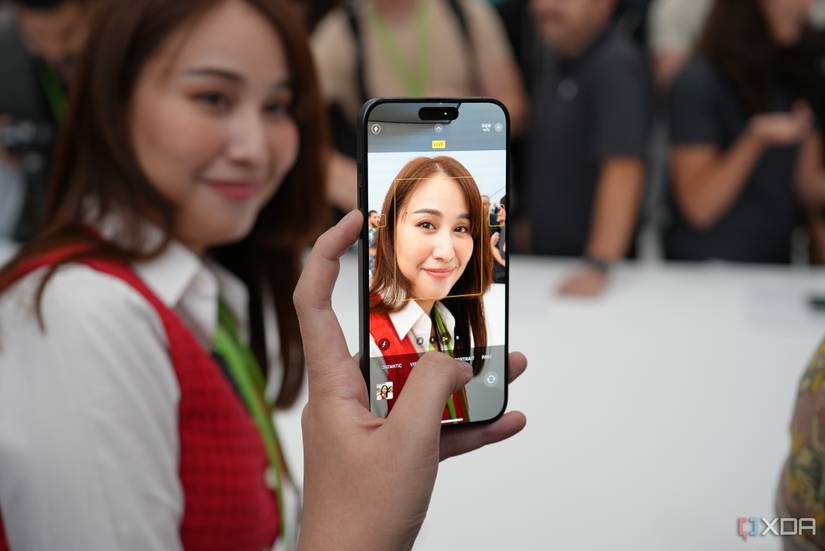 A person taking a photo of a woman on an iPhone 15 Pro Max.