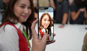 A person taking a photo of a woman on an iPhone 15 Pro Max.