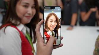 A person taking a photo of a woman on an iPhone 15 Pro Max.