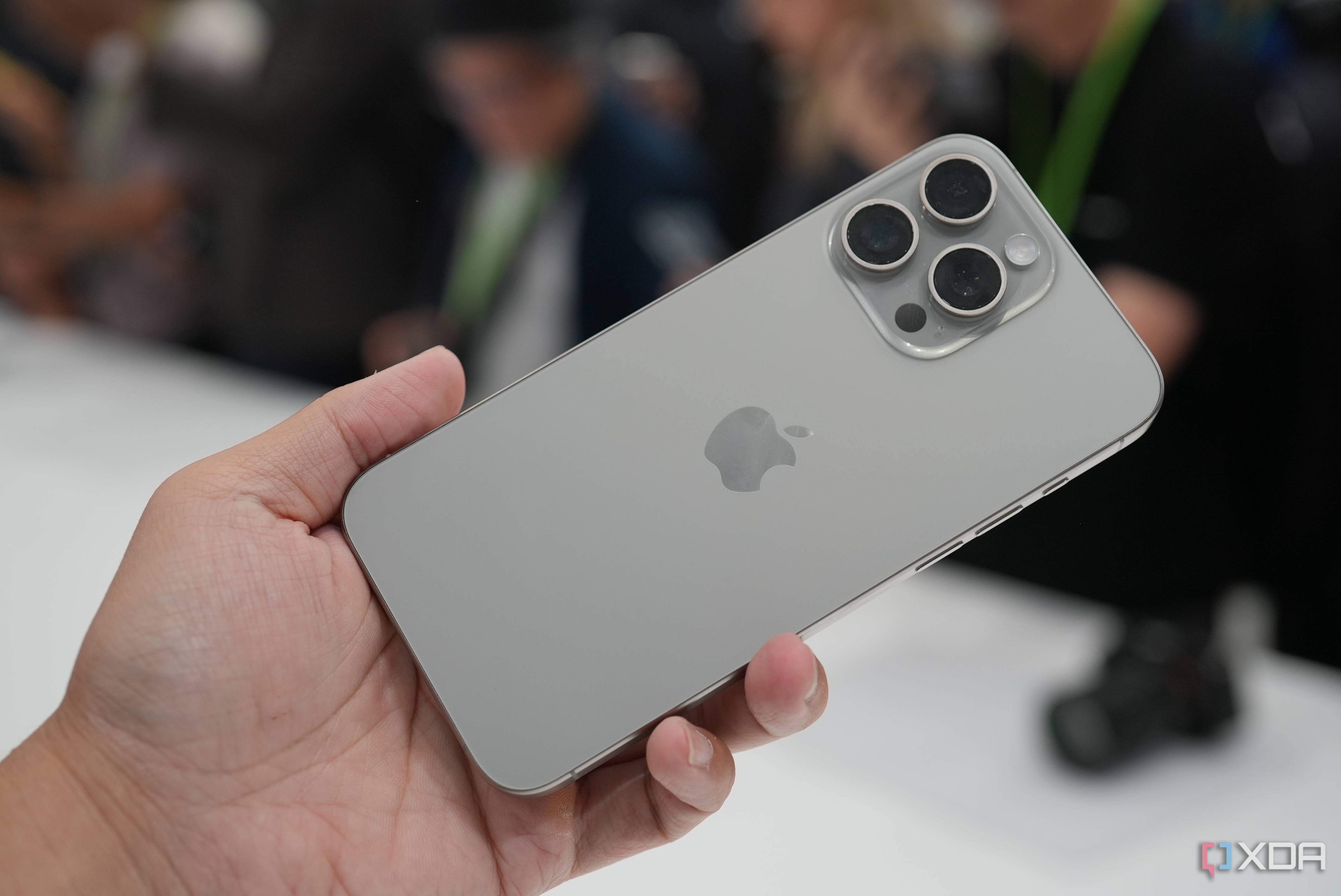 Holding an iPhone 15 Pro Max in Natural Titanium colorway