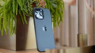 An iPhone 15 Pro Max propped up against a plant.