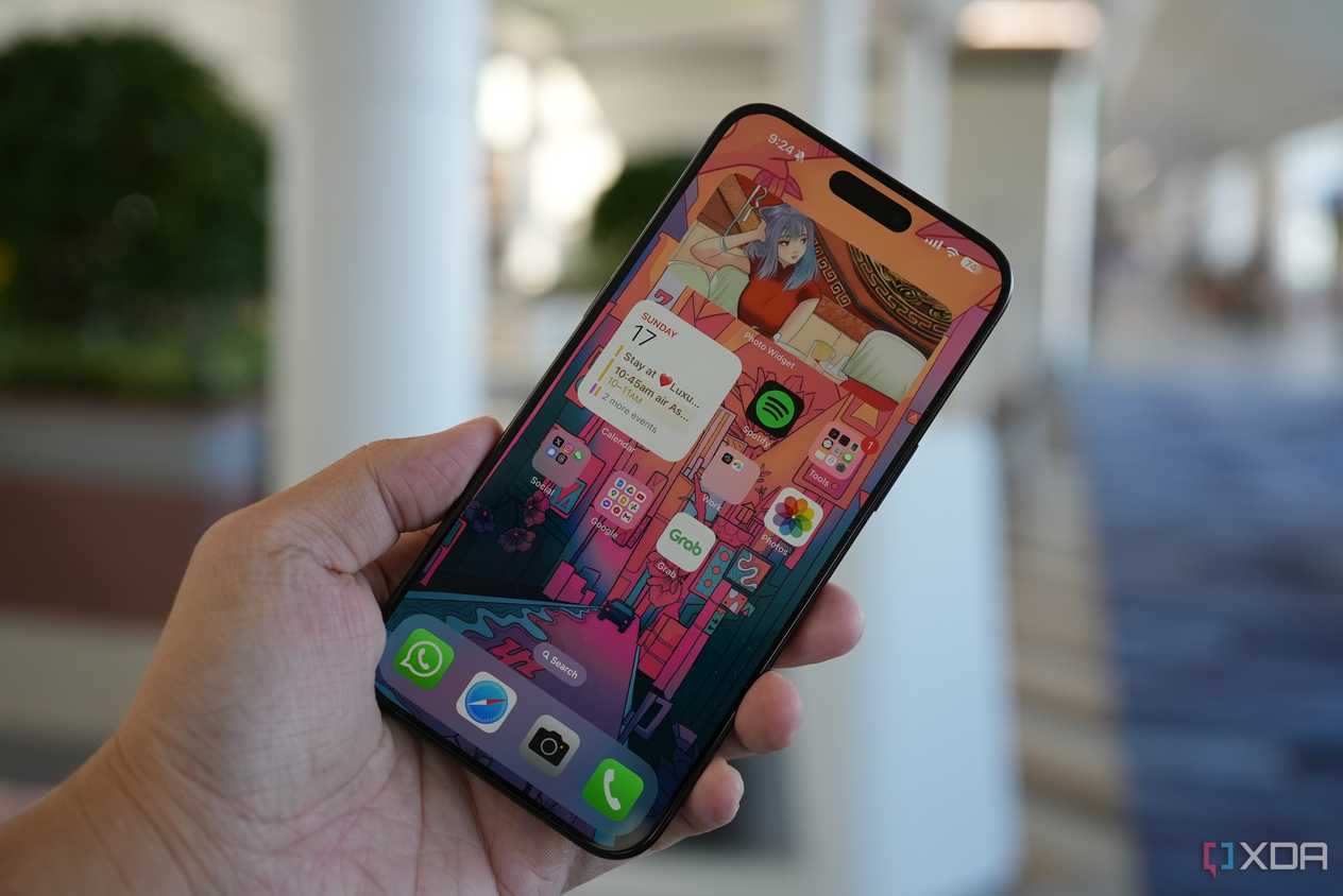 The iPhone 15 Pro Max in the hand with the screen on.