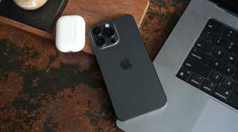 iPhone 15 Pro Max lying on a laptop.