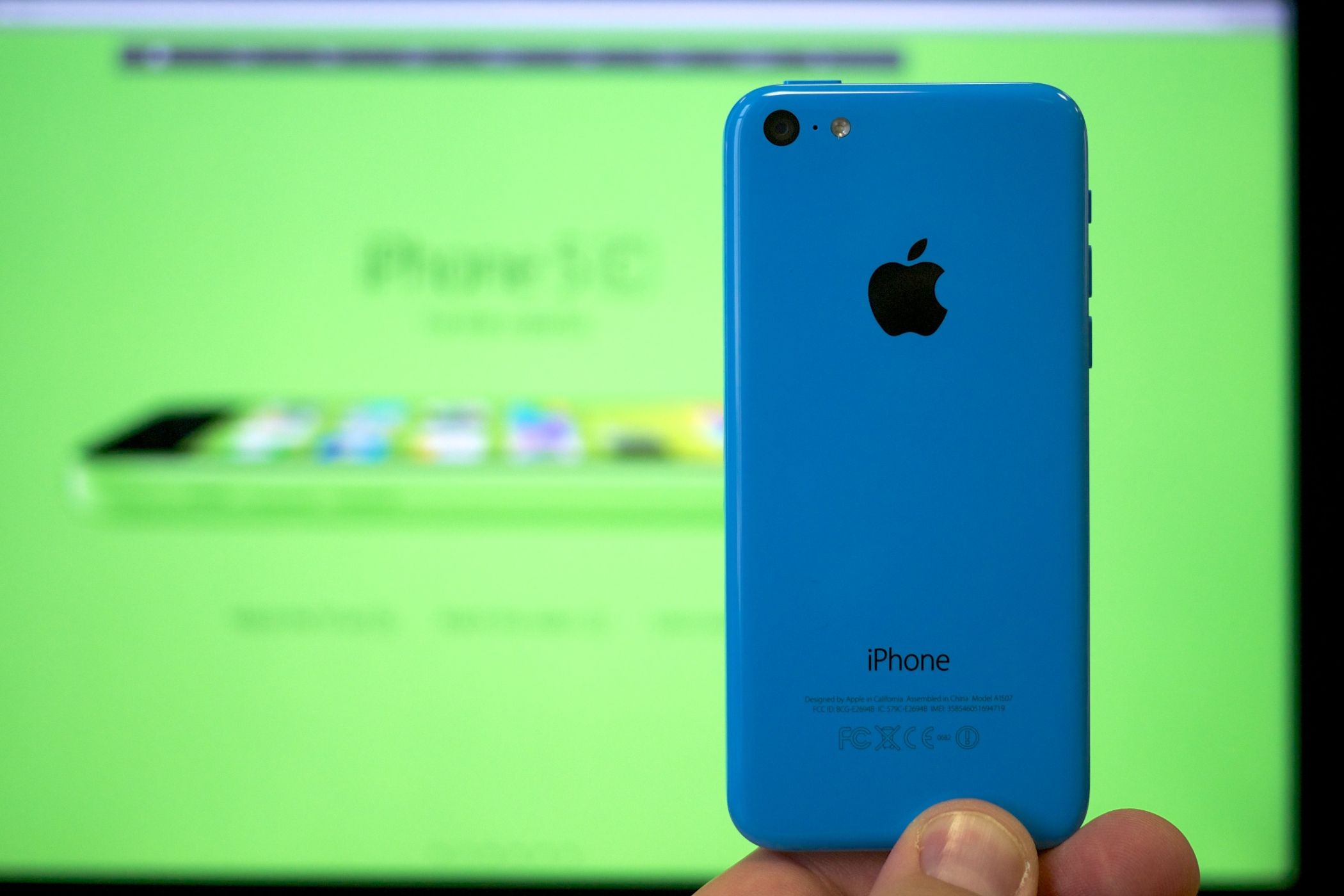 Back of the iPhone 5c blue variant against a big green display