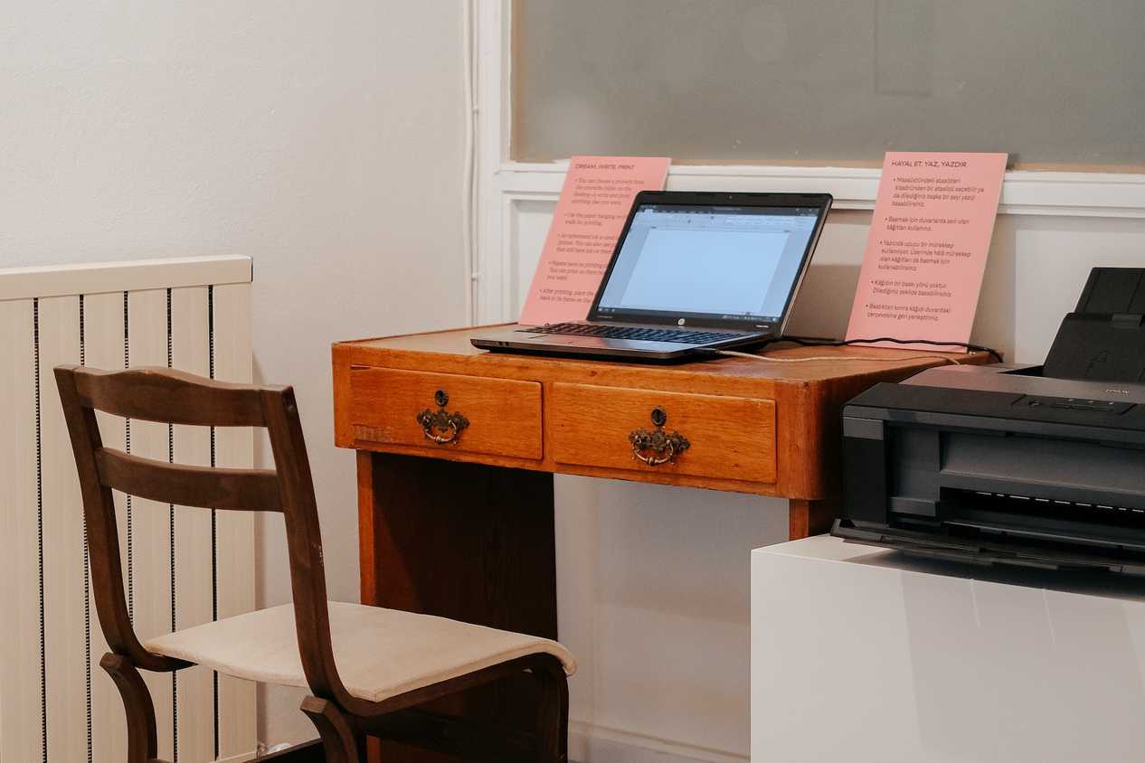 A Windows PC in a minimalistic workspace with a printer connected on the right