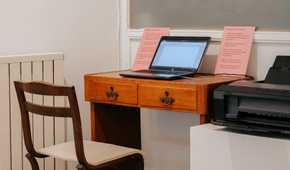 A Windows PC in a minimalistic workspace with a printer connected on the right