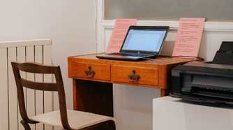 A Windows PC in a minimalistic workspace with a printer connected on the right