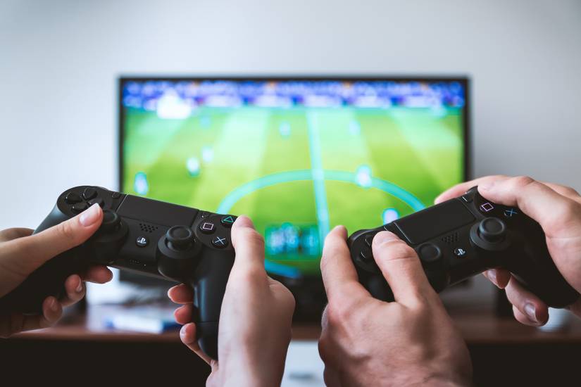 Two people showing hands holding PS4 controllers 