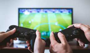Two people showing hands holding PS4 controllers