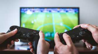 Two people showing hands holding PS4 controllers