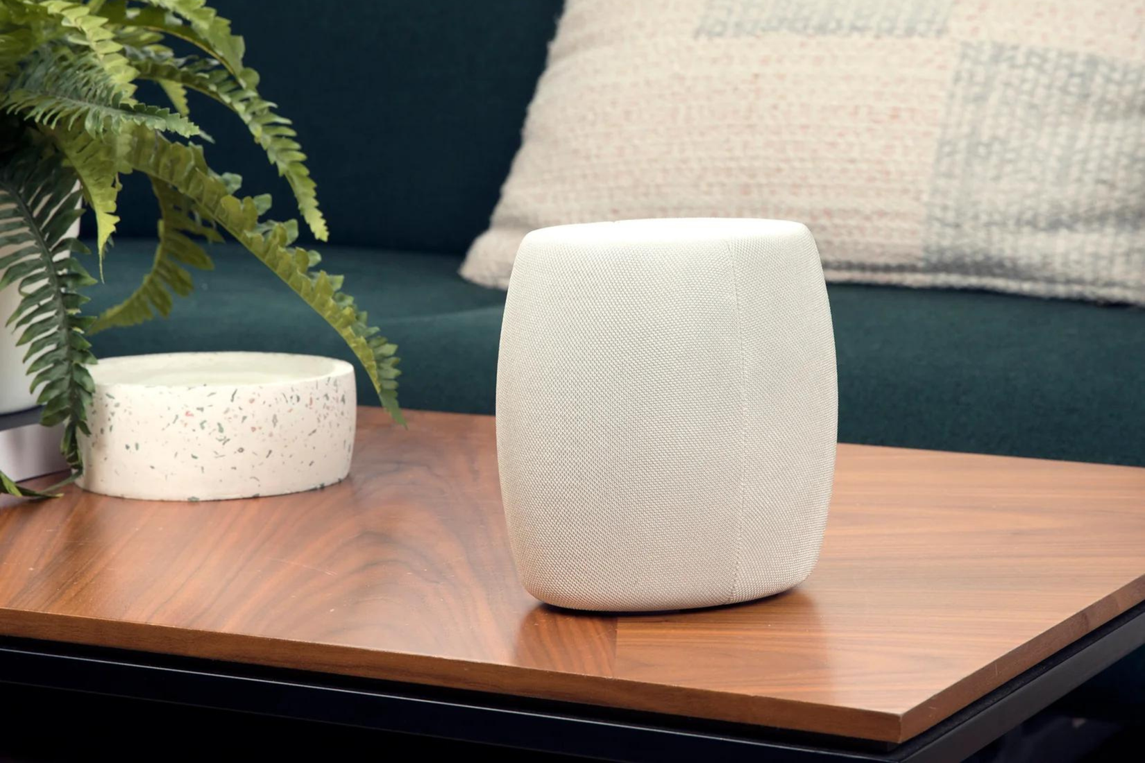 Enrutador Motorola Q14 Mesh WiFi 6E en la mesa de café junto a una planta 