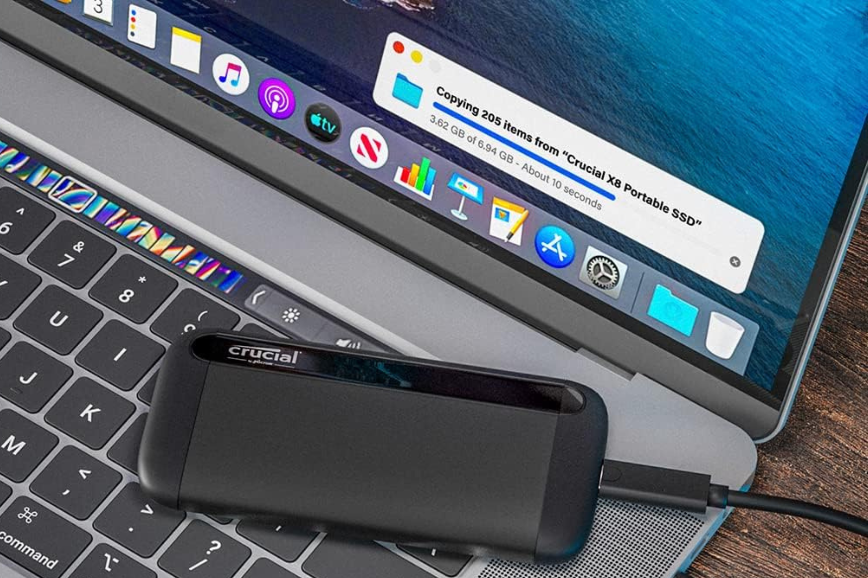 Crucial X8 4TB Portable SSD on top of laptop transferring data 