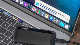 Crucial X8 4TB Portable SSD on top of laptop transferring data