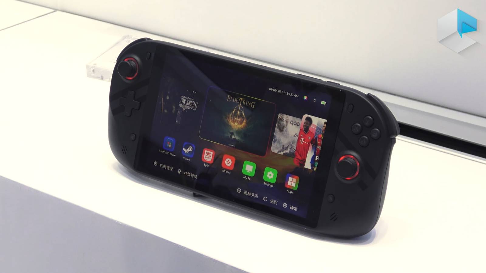 A handheld gaming PC standing up and displaying a menu with multiple games