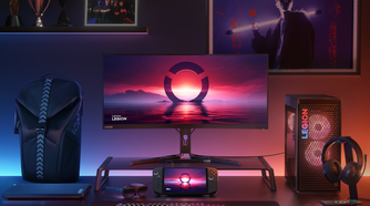 A full Lenovo computer setup to the right, custom RGB backlighting desktop with wallpapers on the wall, a Lenovo laptop to the left, and the Legion Go is in the middle under the computer monitor