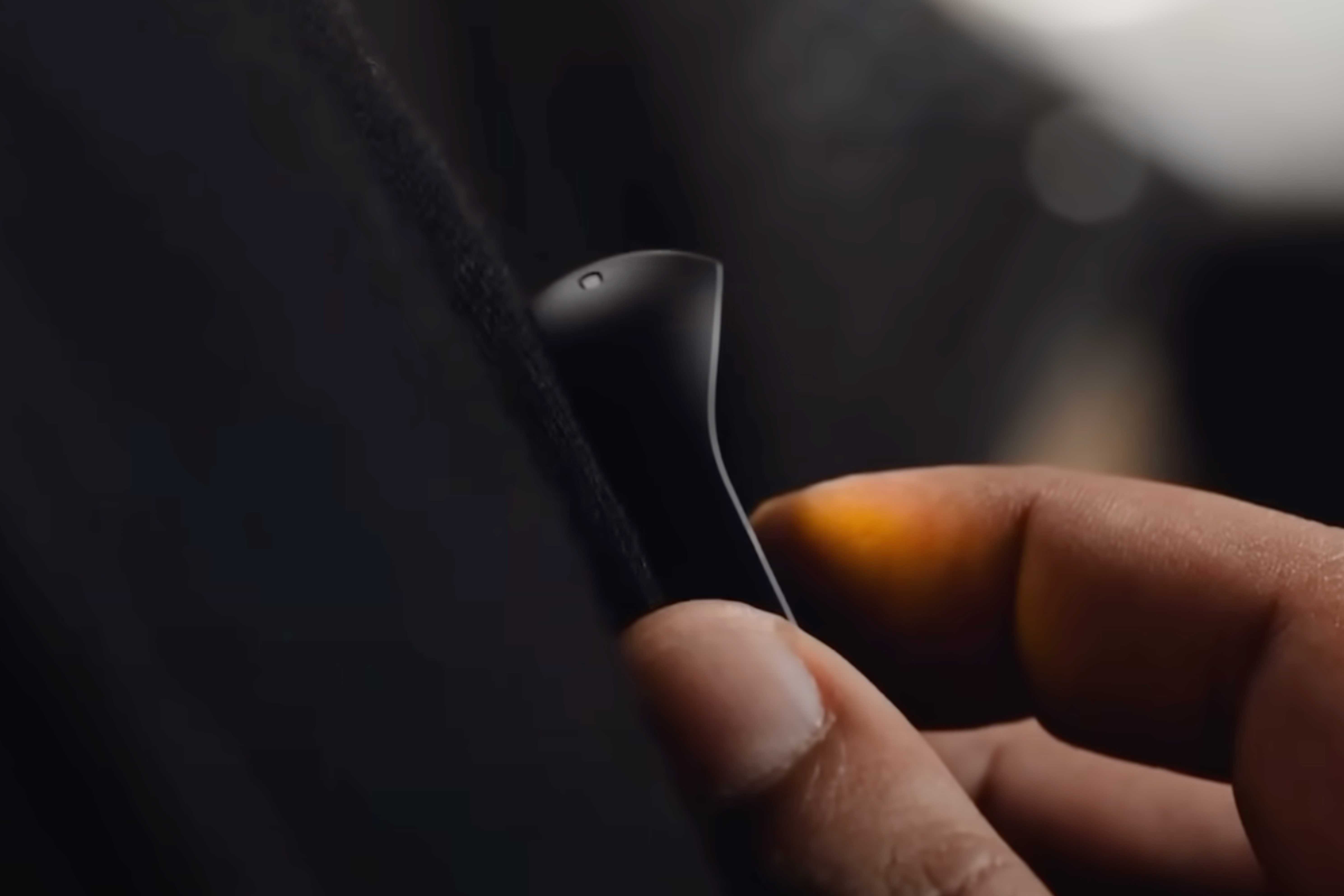 A person controlling the Humane AI Pin with touch.