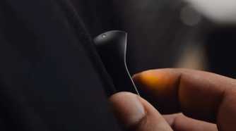 A person controlling the Humane AI Pin with touch.