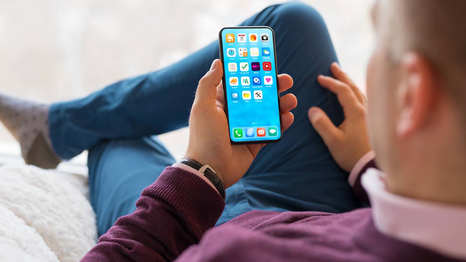 man using smartphone with legs crossed