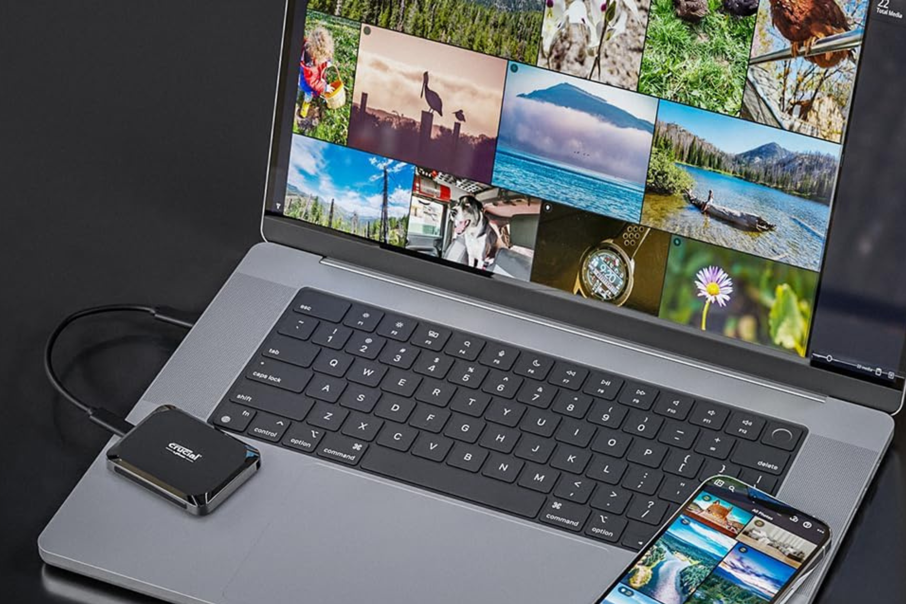 Crucial X9 Portable SSD connected to a MacBook with an iPhone on the side