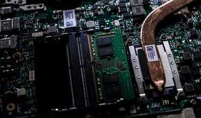 A close up image of a motherboard with a CPU heatsink extending offscreen, the rest of the motherboard is blurred in the background