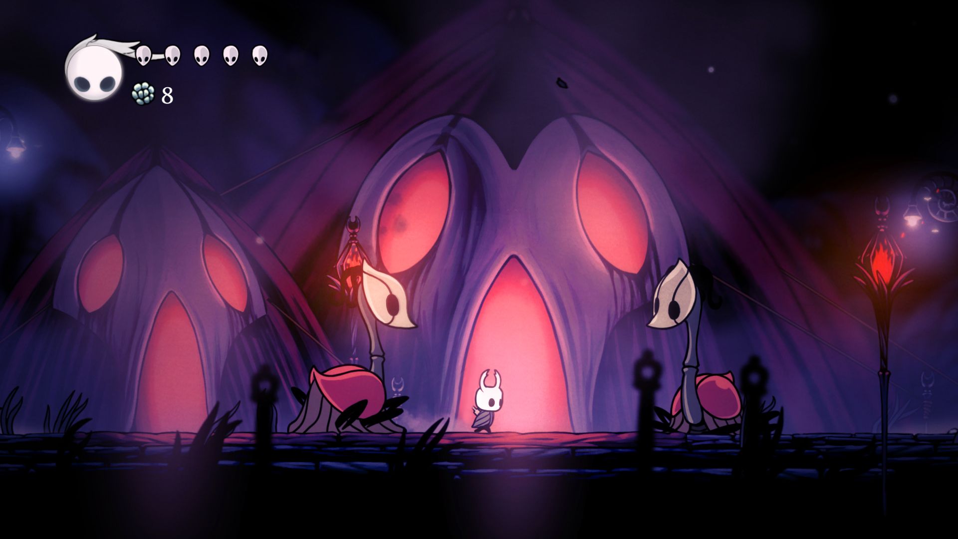 A character standing between two creatures from the game Hollow Knight.